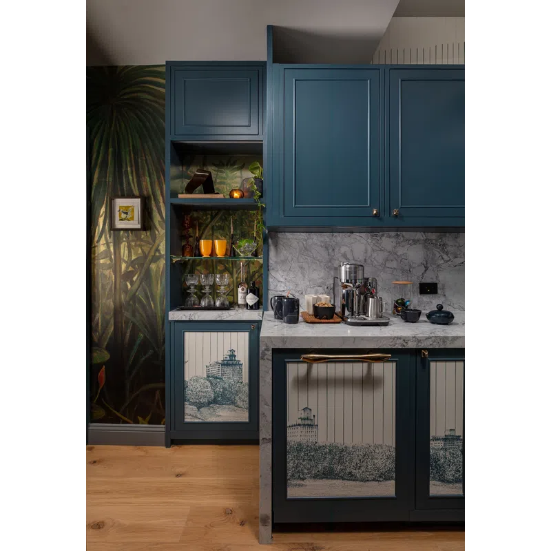 Blue kitchen cabinets with marble countertops, decorative nature mural, wooden flooring, and glassware display.