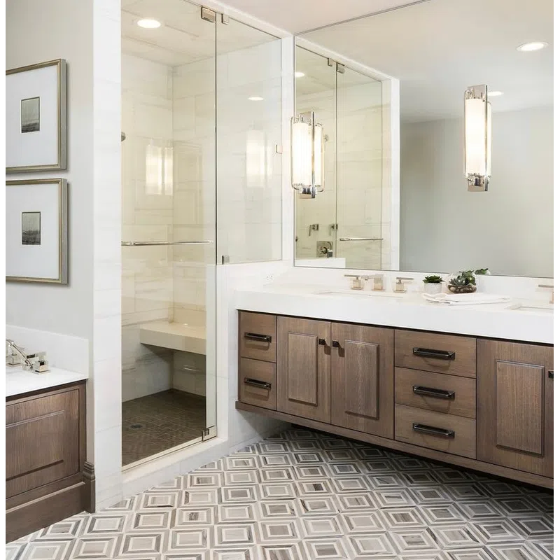 Modern bathroom with wooden vanity, large mirror, glass shower enclosure, geometric tile floor, and wall art.