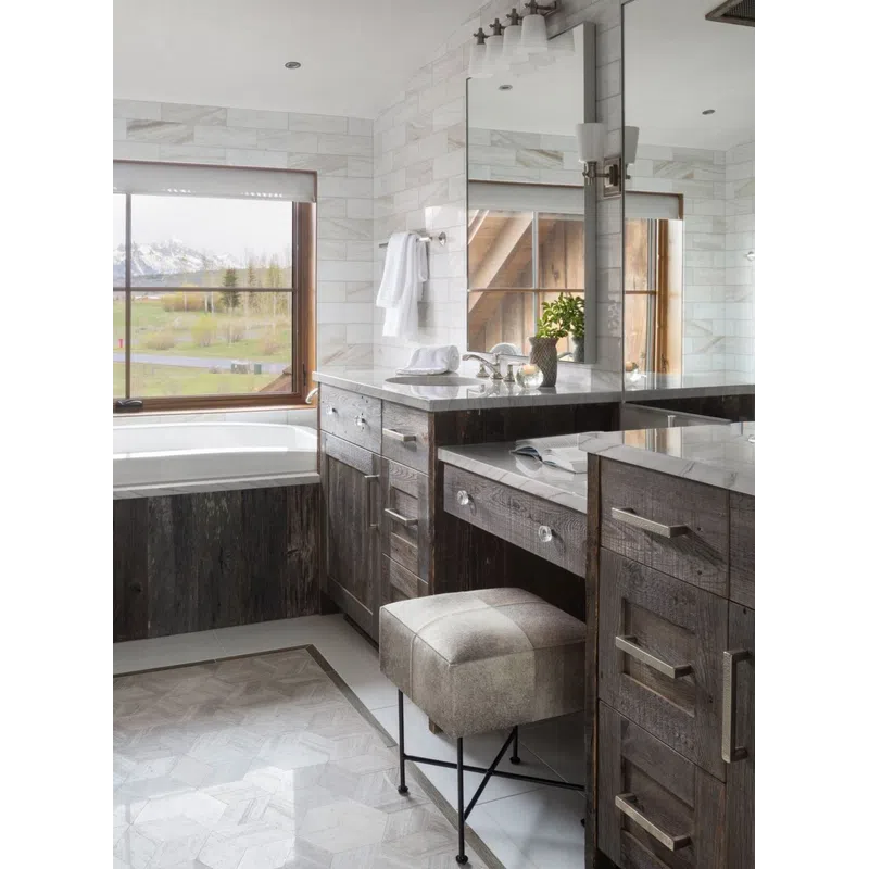 Rustic bathroom with dark wood cabinets, a cushioned vanity stool, marble countertops, and a large window with mountain view.