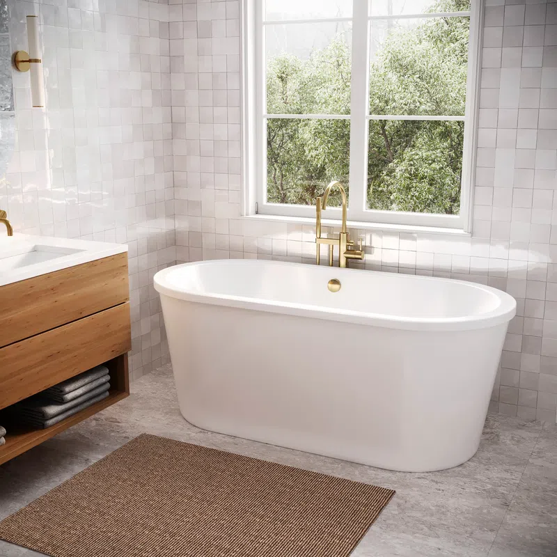 Modern bathroom with freestanding white bathtub, brass faucet, wood vanity, and large window with greenery outside
