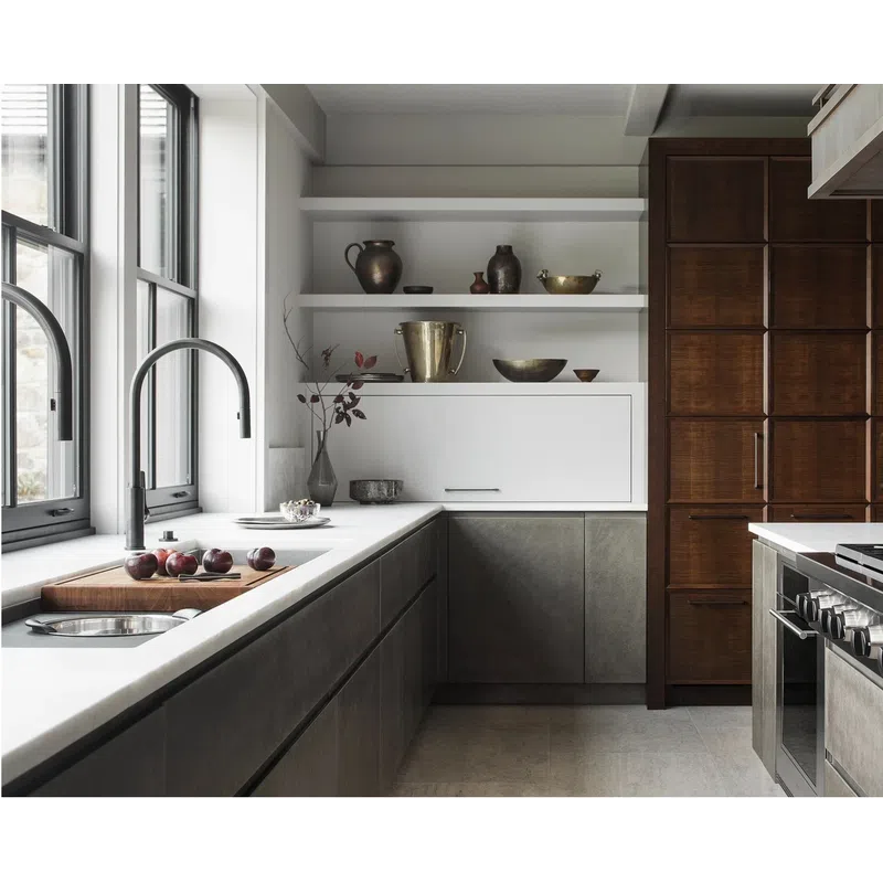 Modern kitchen with gray cabinets, white countertops, wooden pantry, stainless steel stove, and natural light through large windows