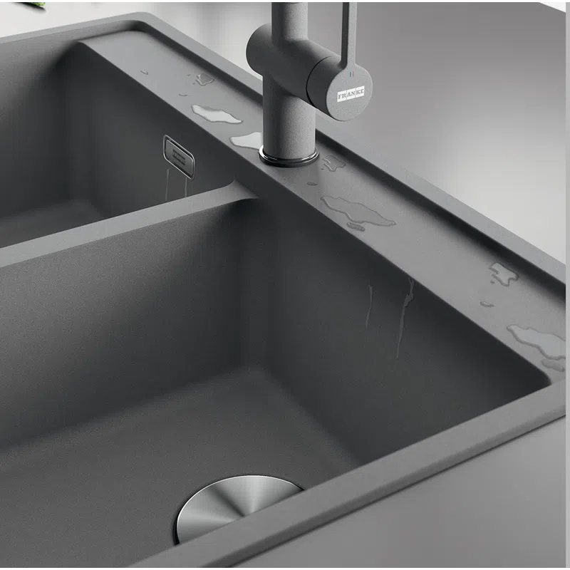 Modern matte gray double kitchen sink with water droplets and stainless steel drain and faucet.