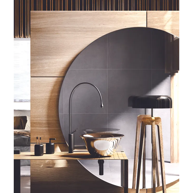 Modern bathroom with round mirror, black faucet, wooden countertop, and stylish lamp in natural light.