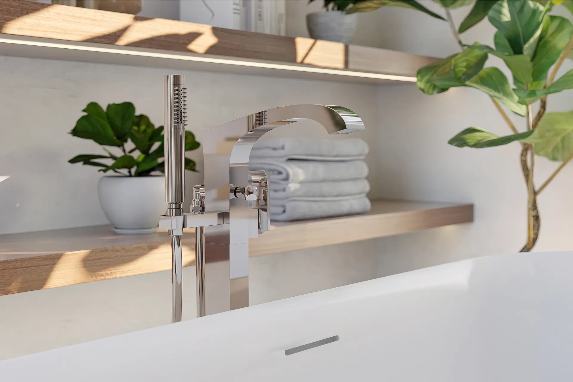 Crosswater Leyden deck-mount tub faucet with handshower on a ledge with folded towels and plants.
