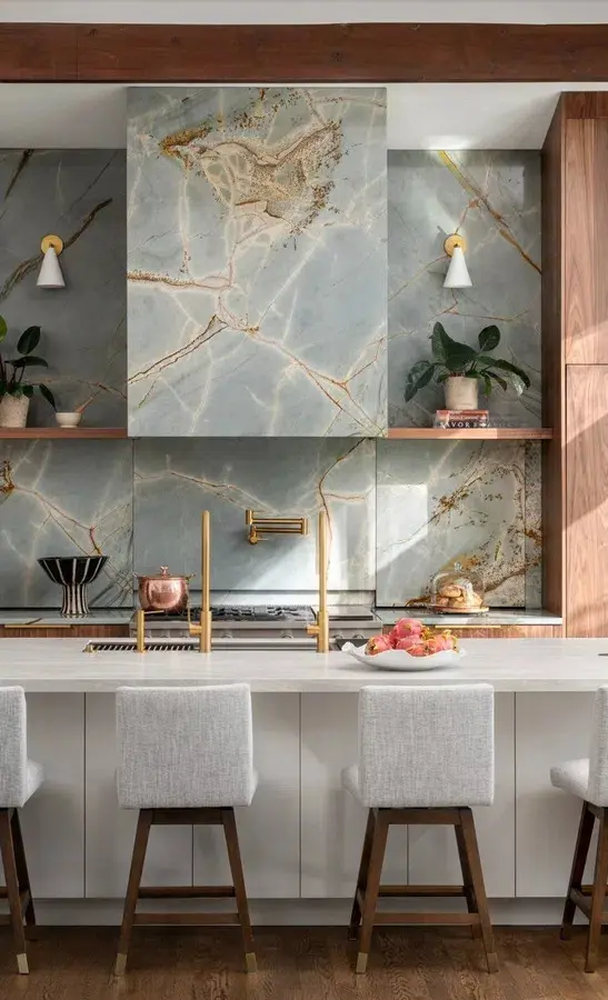 Modern kitchen island with a marble waterfall countertop and integrated Galley Workstation sink.