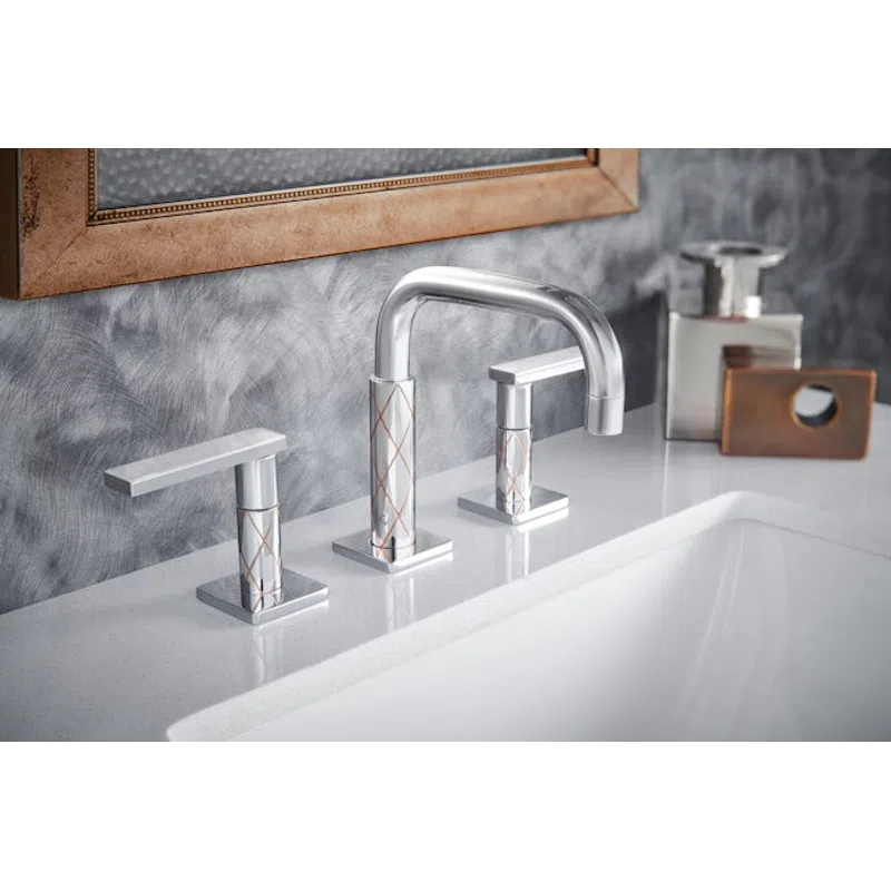 Modern chrome bathroom faucet with geometric pattern on white countertop and textured gray wall.