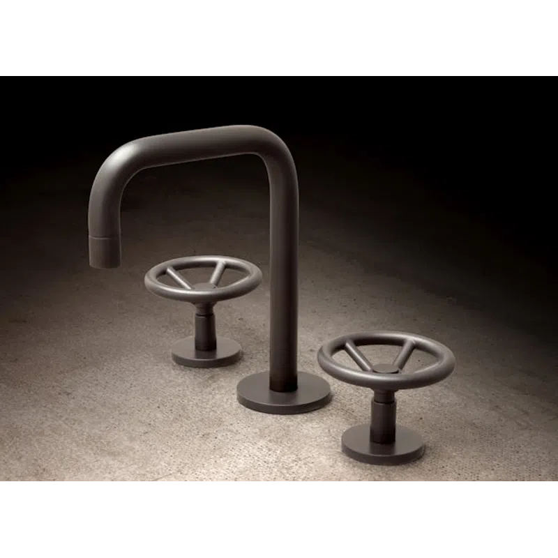 Modern industrial-style faucet with two round wheel handles on a concrete surface, lit with soft shadows.