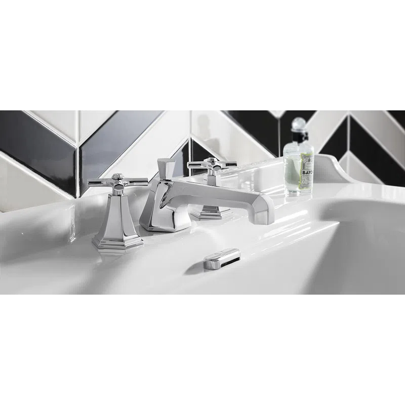 Modern chrome faucet and handles on white sink with black and white chevron tile backsplash.